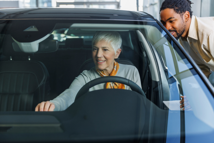 A woman trying the dashboard of a car at a dealership